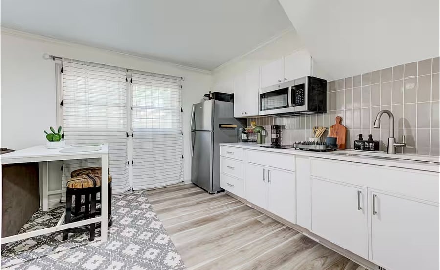 The dining area features a full size refrigerator, and cozy table with two stools by the window. Creating the perfect spot to enjoy meals or sip your morning coffee.
