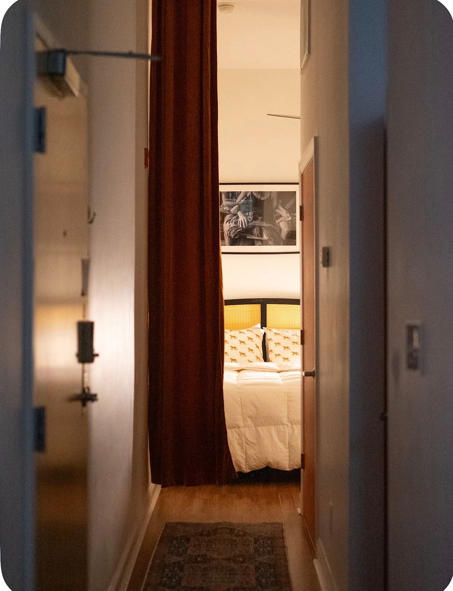 The hallway going into the bedroom allows for the use of luxurious velvet ceiling to floor burnt orange drapes for a relaxing atmosphere.