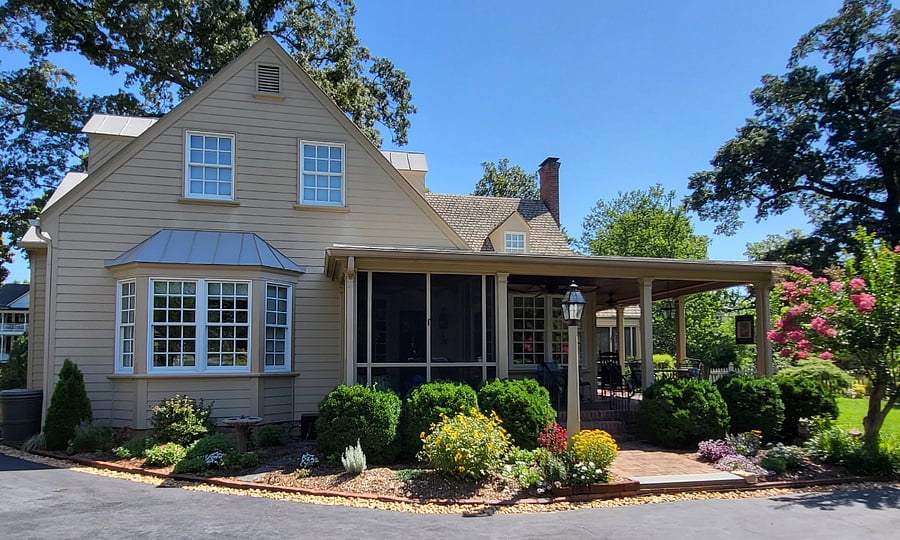 Back of our home with screened and large open porch. This addition to the original house was built in 2012. Table and chairs for outdoor dining.
