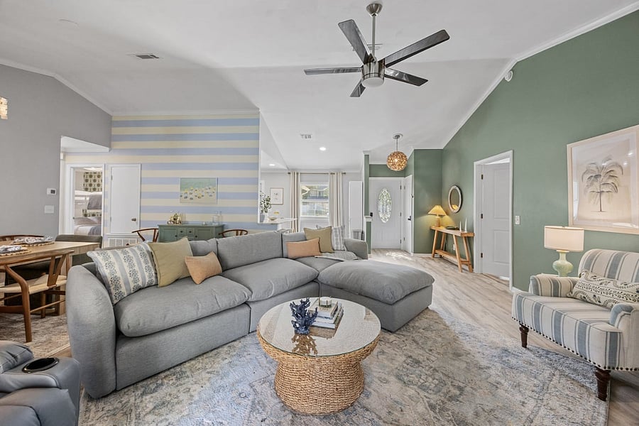 Bright coastal living room with vaulted ceiling and oversized sectional.