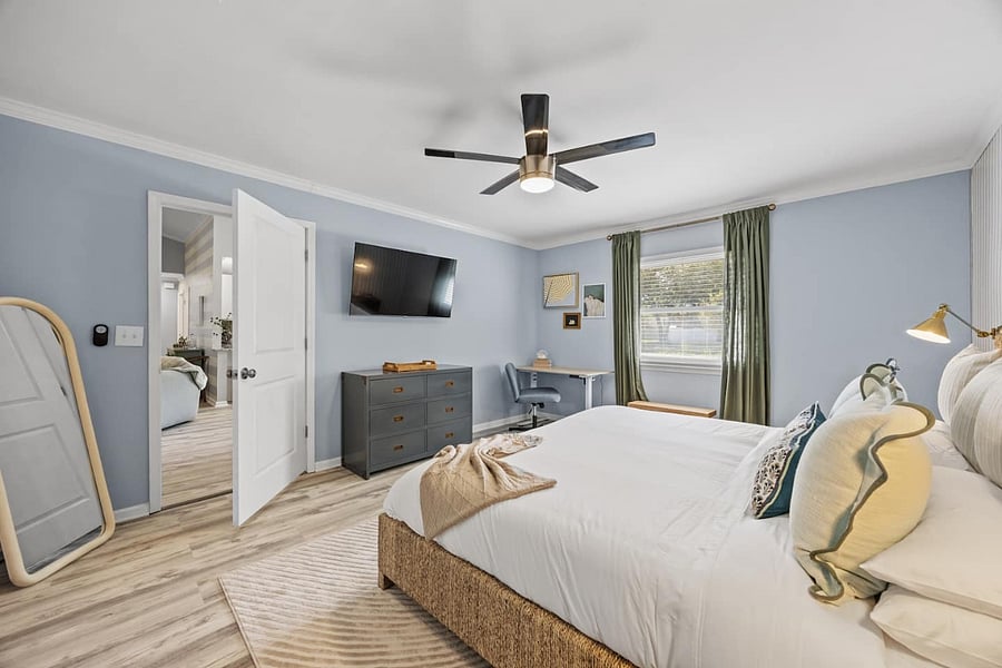 A spacious, accessible primary bedroom designed for effortless flow.  The wide door opening, open layout, and clear pathways around the king bed, workspace, and closet make movement smooth and comfortable for every guest.