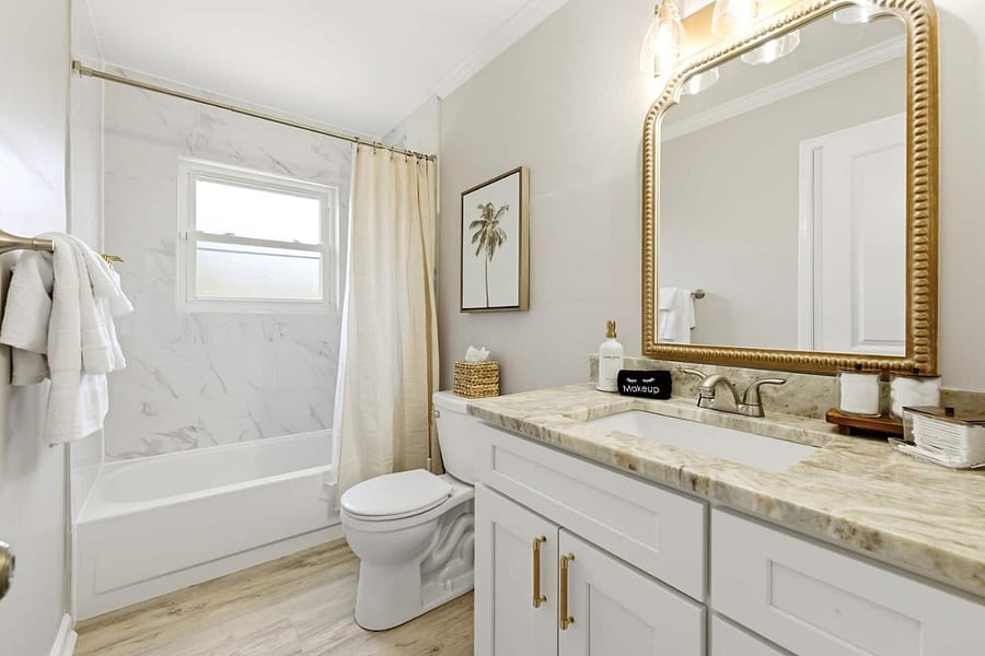 Bright, modern bathroom with a marble-look shower, a spacious vanity, and plenty of storage.