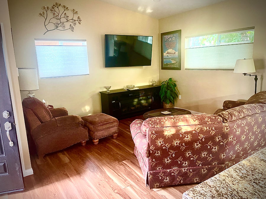 Large living room with fireplace and large smart TV, another smart TV is in bedroom.