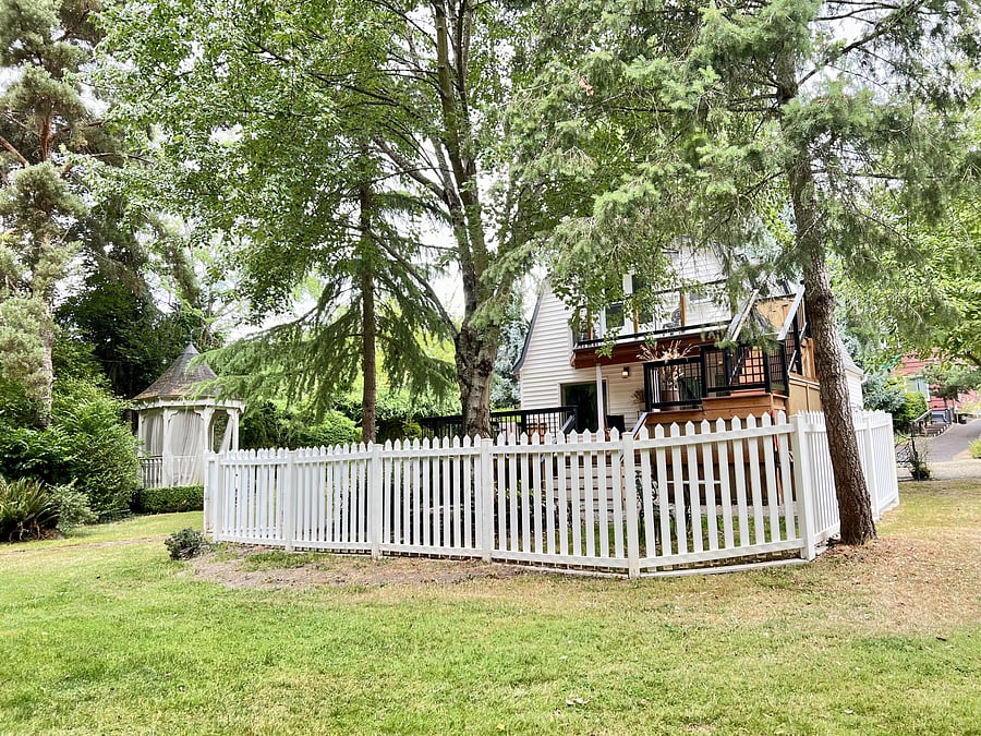 Private deck, balcony and fenced yard within a gated park-like acre property.