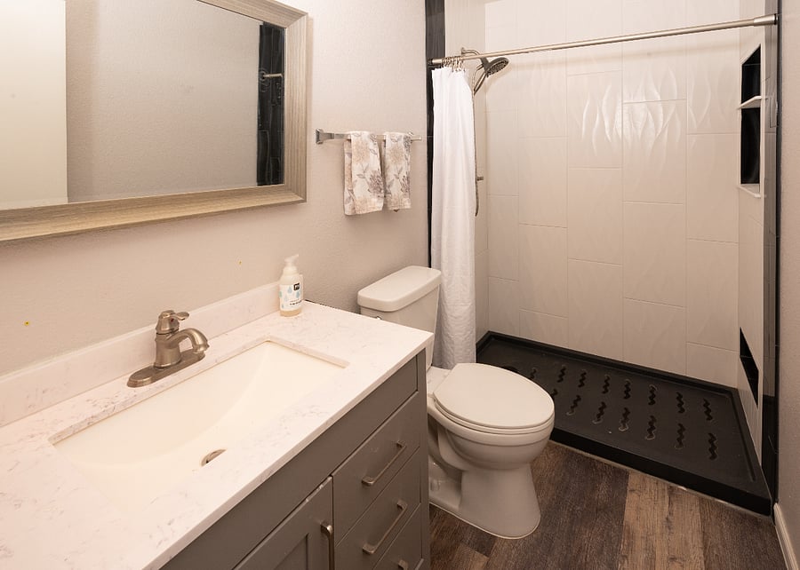 Primary bedroom's ensuite bathroom with new walk in shower- good space counter top and drawers and a medicine cabinet on side wall