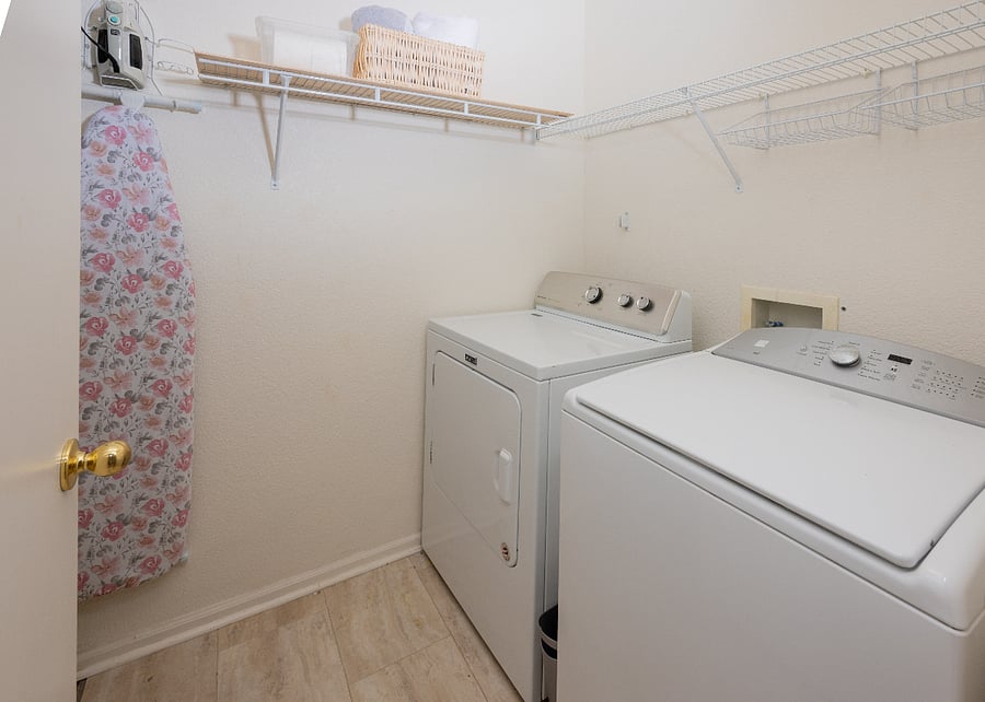 Upstairs laundry - full size W and D. Ironing board, hanging space, upper storage.