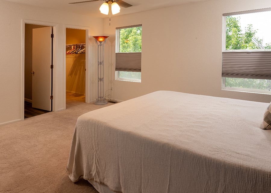 Primary bedroom, looking from the bed, the walk in closet, and ensuite bathroom door.