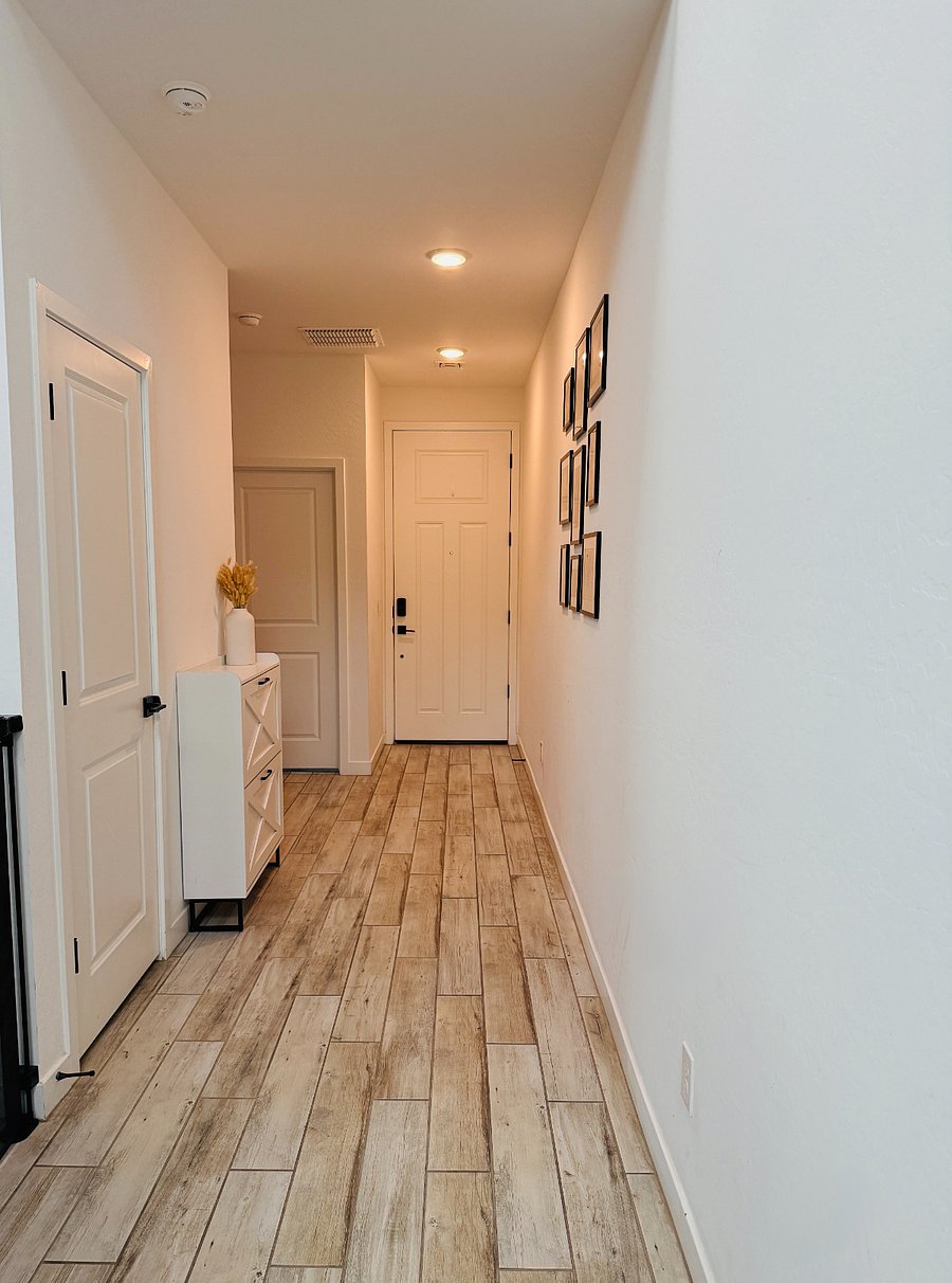 A beautifully decorated hallway welcomes you home, offering a bright, inviting entryway with a convenient bedroom and bathroom situated just to the right.