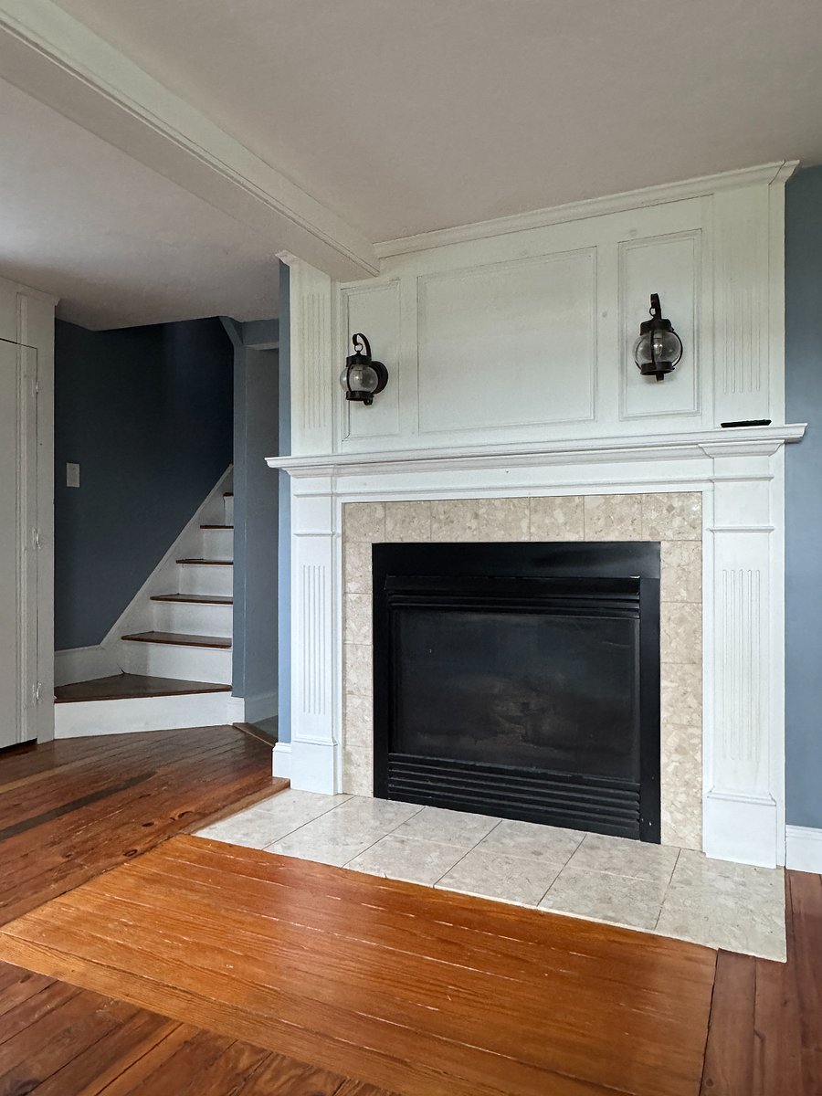 Gas fireplace and view of stairs leading to bedrooms and bathroom