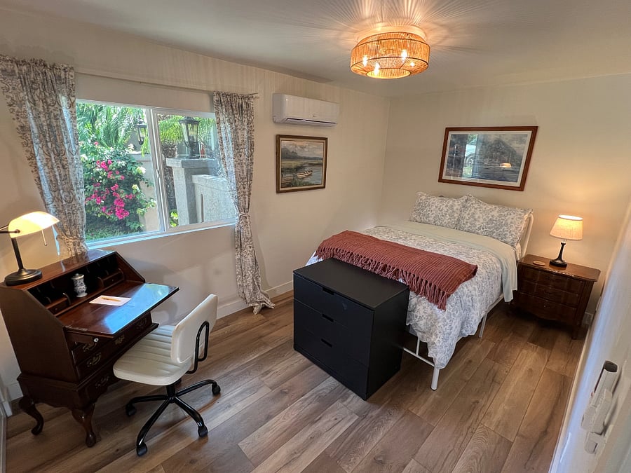 Secondary bedroom with full-sized bed, dresser and secretary desk.