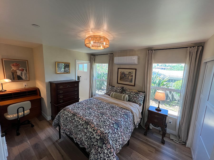 Cozy primary suite with desk and attached full bath. Full-sized bed with memory foam mattress and mattress topper. Large closet with paneled sliding doors.