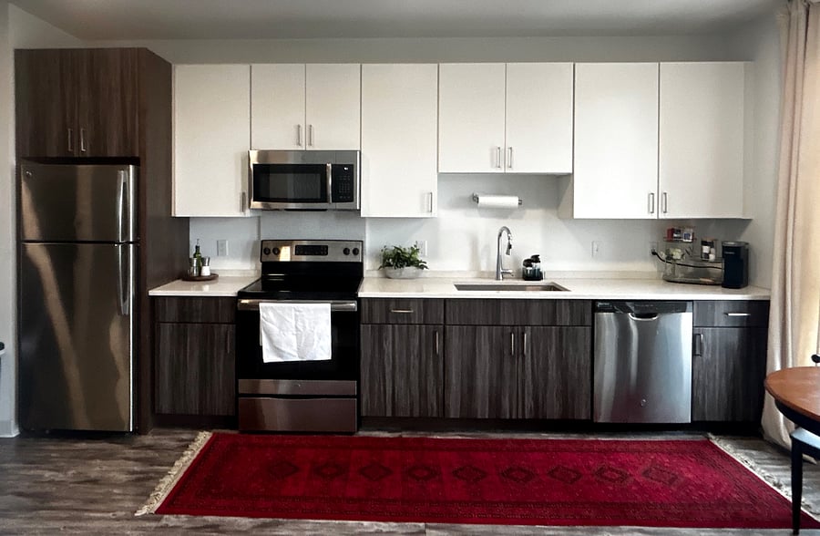 Fully equipped kitchen with stainless steel appliances, dishwasher, and quartz countertops.