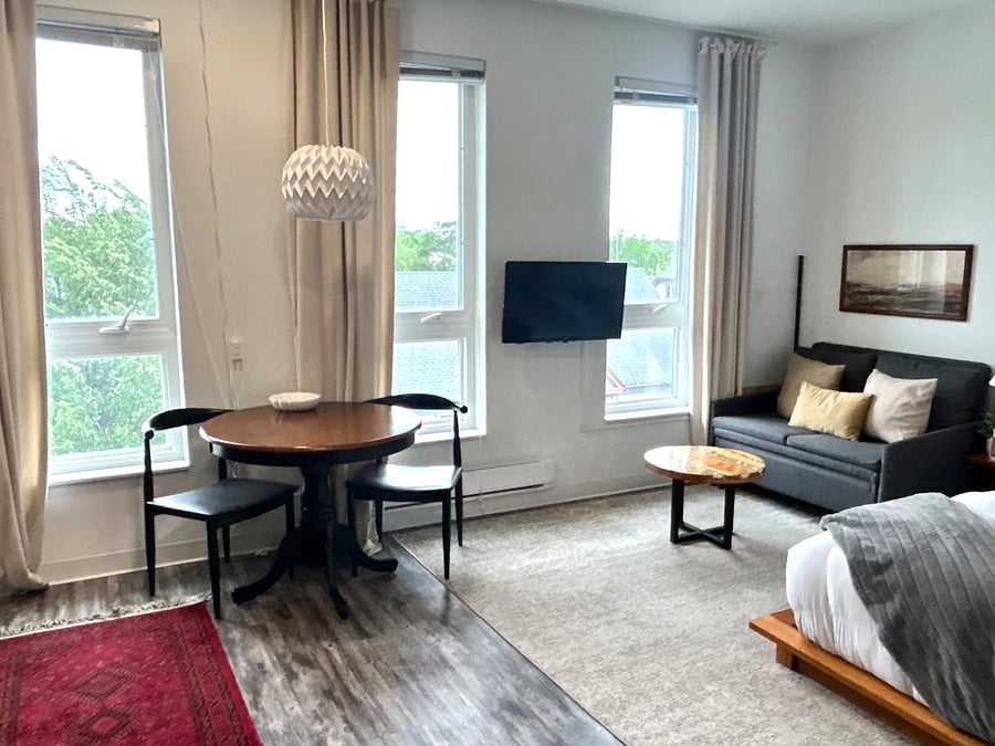 Bright, open living space with a cozy dining nook and wall-mounted TV.