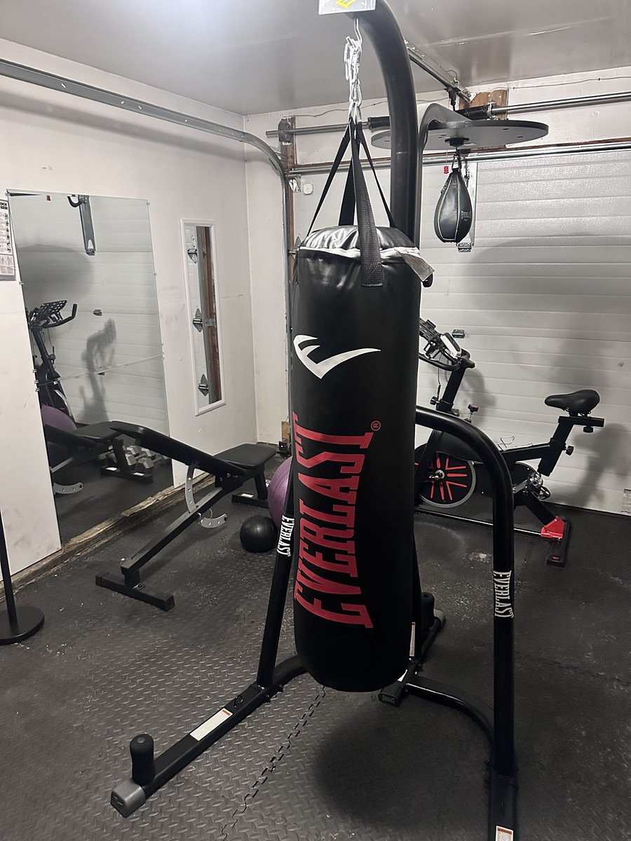Heavy bag, stationary bike, dumb bells, workout bench, and exercise ball.