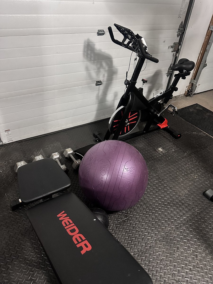 Heavy bag, stationary bike, dumb bells, workout bench, and exercise ball.