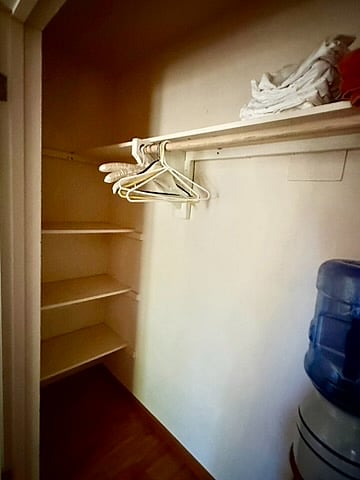 left side of closet with storage space and room for hanging clothes.