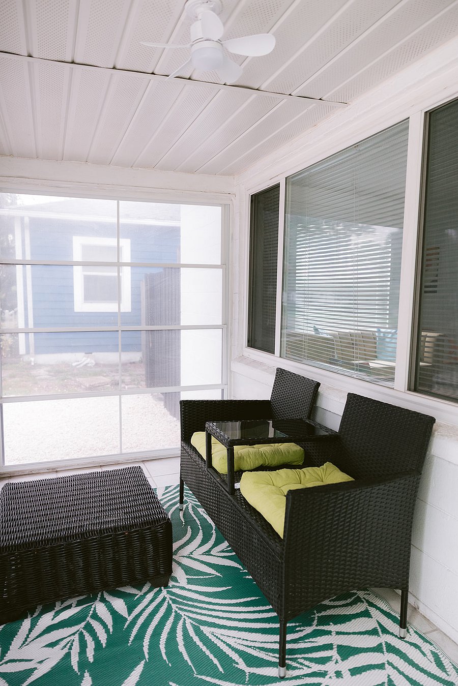 ENCLOSED SITTING FRONT PORCH WITH WICKER SEATING & OTTOMAN