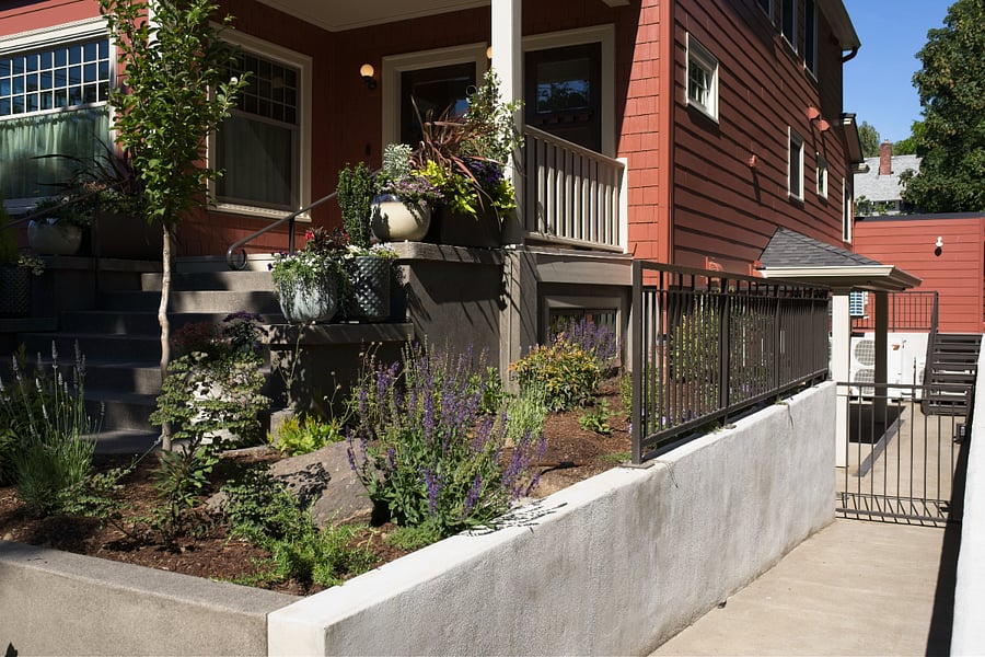 Sloped gated entrance to shared basement patio.