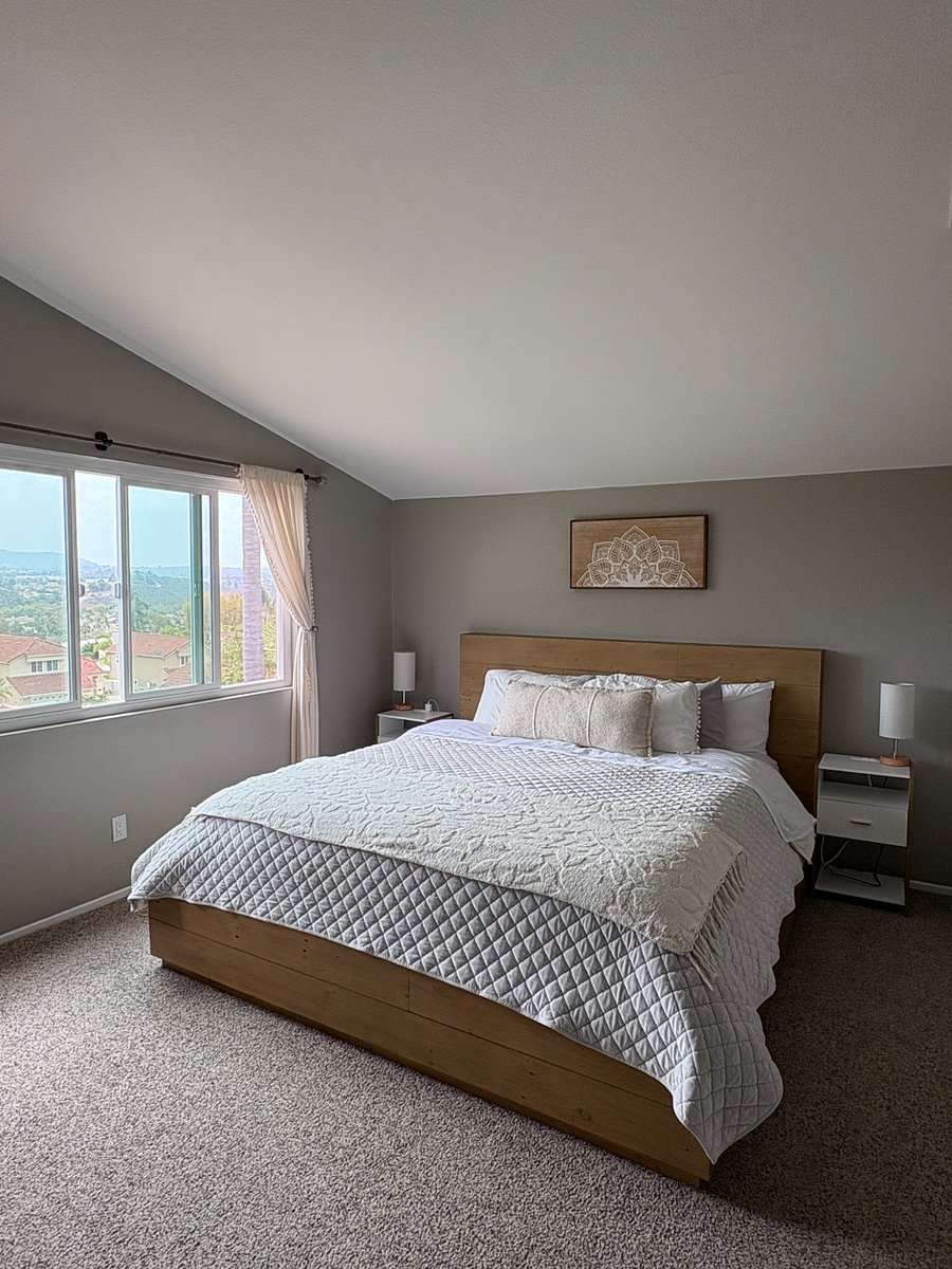 King bed in primary bedroom. Large smart TV mounted on wall
