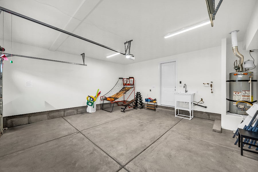 Garage with games, work out equipment, and a utility sink.