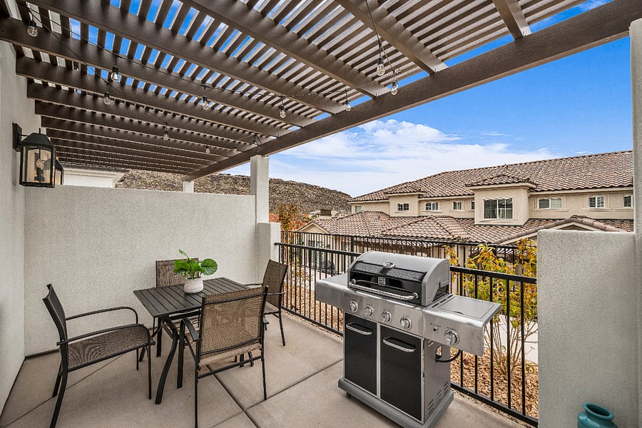 Front patio with gas grill, lighting and table and chairs.