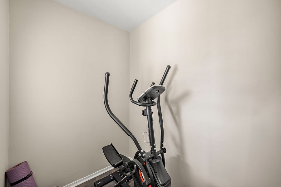 Exercise room (elliptical, adjustable free weight, bench, and yoga mat)