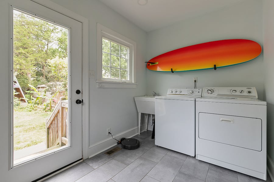 The spacious laundry room opens out to the large, fully fenced, landscaped backyard that is perfect for dogs, kids, and adults alike. Featuring cafe lighting, a fire pit, gas grill, hand built play fort, and small scale concrete skate ramp, you wont find a backyard like this anywhere else. 
