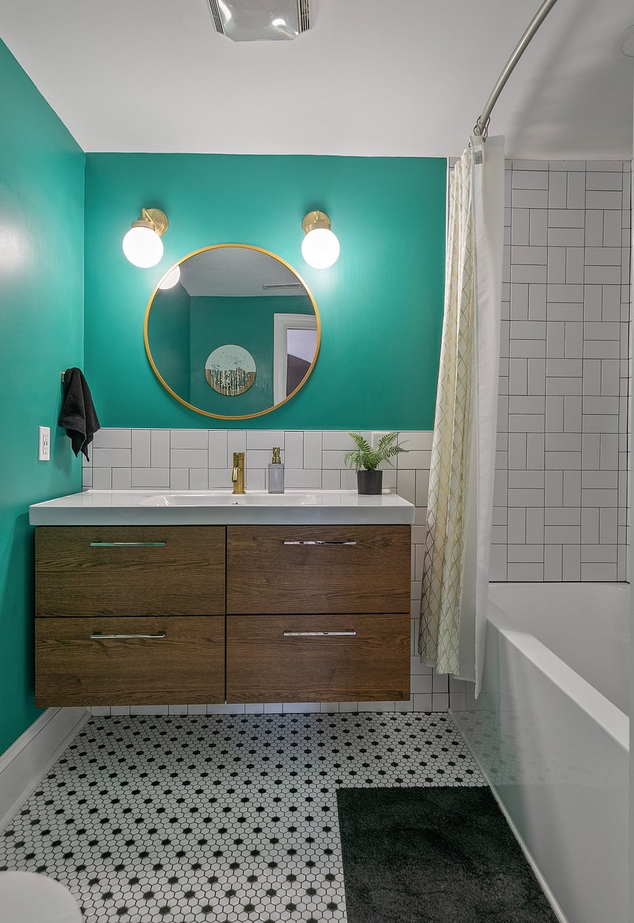 The upstairs full bath features brass fixtures and custom tile work.