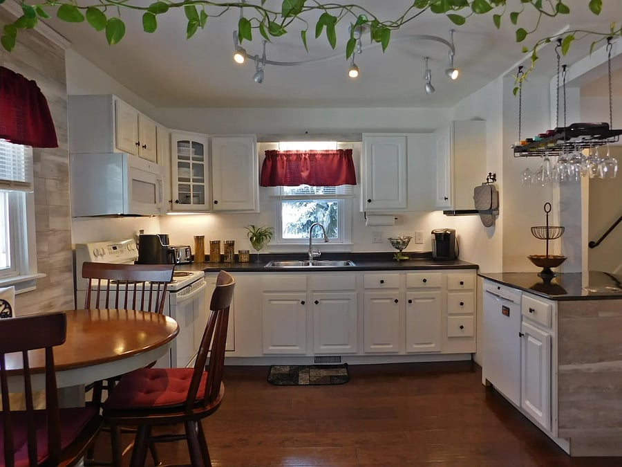 Full kitchen with electric stovetop, oven, full-size refrigerator, dishwasher, air fryer, Kureg coffee machine, microwave, and dinind table.