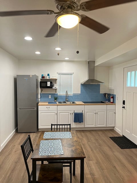 4 top burner with vented hood
microwave
full refrigerator
stainless steel sink
butcher block countertop
small air fryer
other kitchen essentials: utensils, pots, pans, cups, plates, etc.