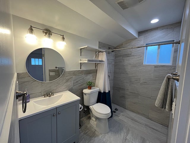 walk-in shower
tile floor/walls
storage below sink and above toilet
vent and heater