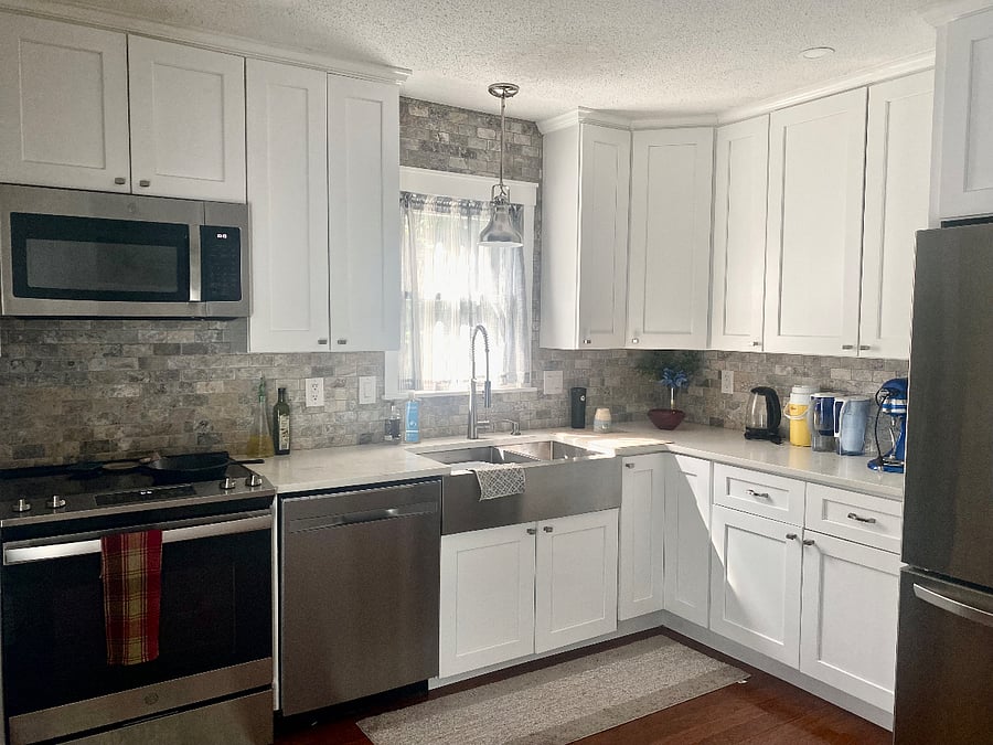 Bright, Light Kitchen with Ample Space for Cooking Meals. Full Stocked with Pots, Pans, Knives, Silverware, Plates and Cups.