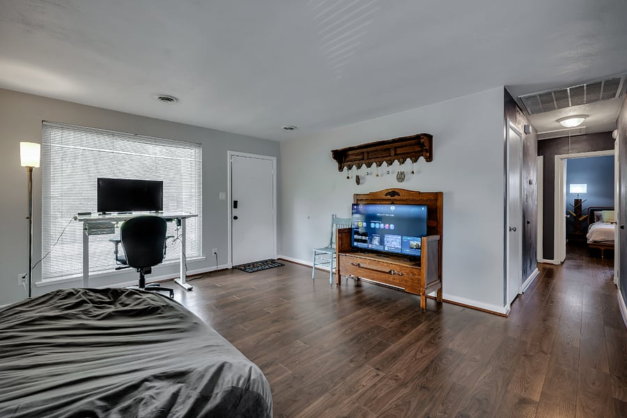 View of front door and dedicated office space with adjustable height desk.