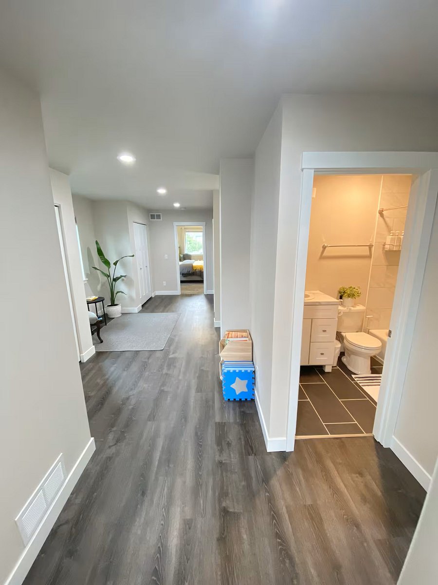 View from the dedicated office room, across the bonus area from the primary bedroom, with a restroom close by. Bonus area doubles as a small kids play-area with some additional children's amenities.