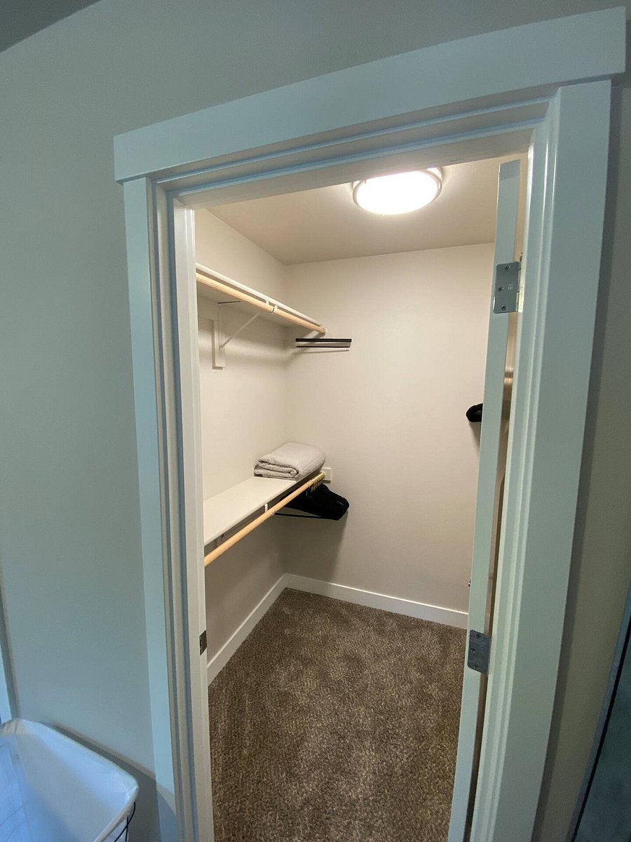 The walk-in closet in the primary bedroom holds extra pillows and blankets as well as the luggage racks for this room