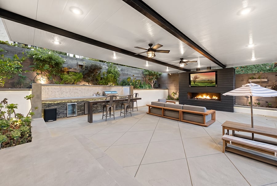 Indoor-Outdoor Covered Patio & BBQ
Al fresco dining at its finest! The expansive covered patio features multiple ceiling fans, an outdoor kitchen with a built-in BBQ, a cozy lounge area with a fireplace and flat-screen TV, and casual dining seating.
