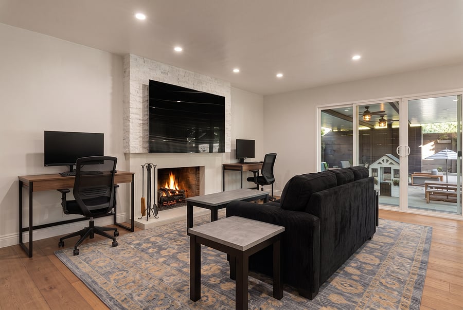 First-Level Family Room & Home Office
Multifunctional bliss! Your 1st-floor oasis features a cozy fireplace, dual-desk workstation, plush sectional, smart TV, and sliding glass door to a covered patio. Ideal for a family film night or remote work.