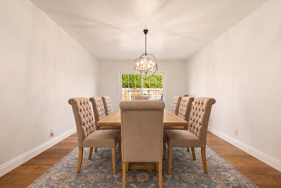 Dedicated Dining Room
Sophisticated dining! Gather at the large wooden table in this elegant room, with tufted beige chairs, a patterned area rug, and sliding glass doors to the backyard.