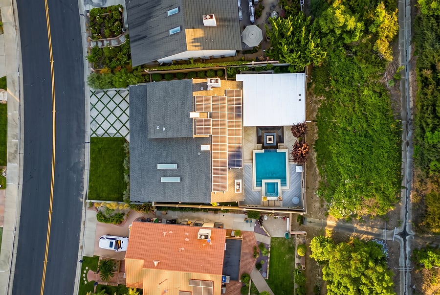 Aerial Bird's-Eye View
Aerial bird's-eye view of your private haven! See the unique roofline, solar panels, and sparkling pool, all bordered by rich natural hills. A true retreat from above.