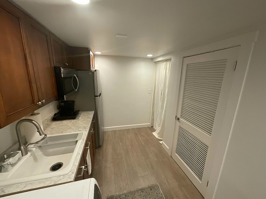 Additional kitchen & laundry area. Beyond curtain is workout area.