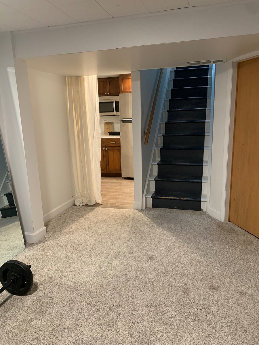 Come down basement steps to apartment behind curtain