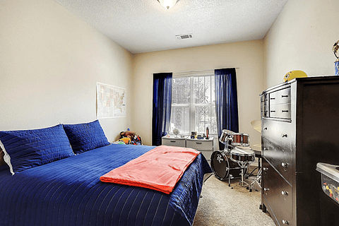 Front Bedrrom - Queen Bed & Dresser. The window looks out to the street/front yard.