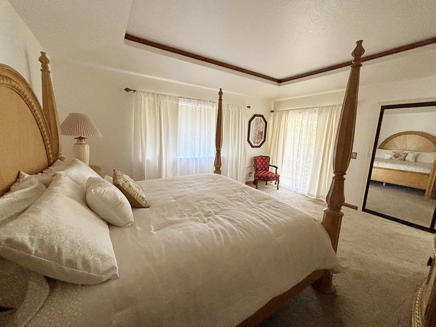 Primary bedroom with slider door access to outdoor covered patio area