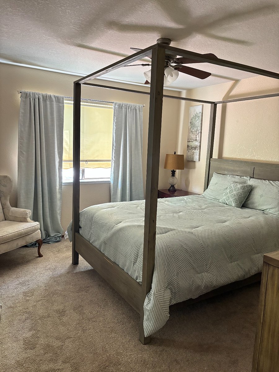 Bedroom with queen sized bed, dresser, nightstand and chair