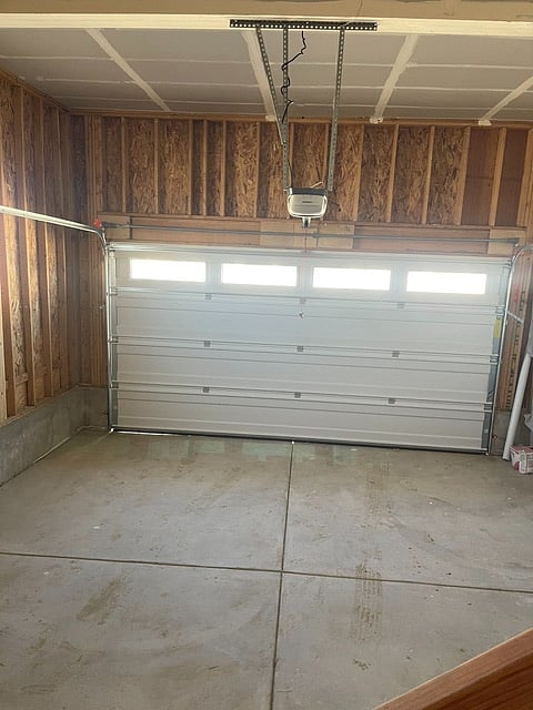 Attached 2-car garage which connects to the kitchen. There are also mounted industrial shelves that provide extra storage. 