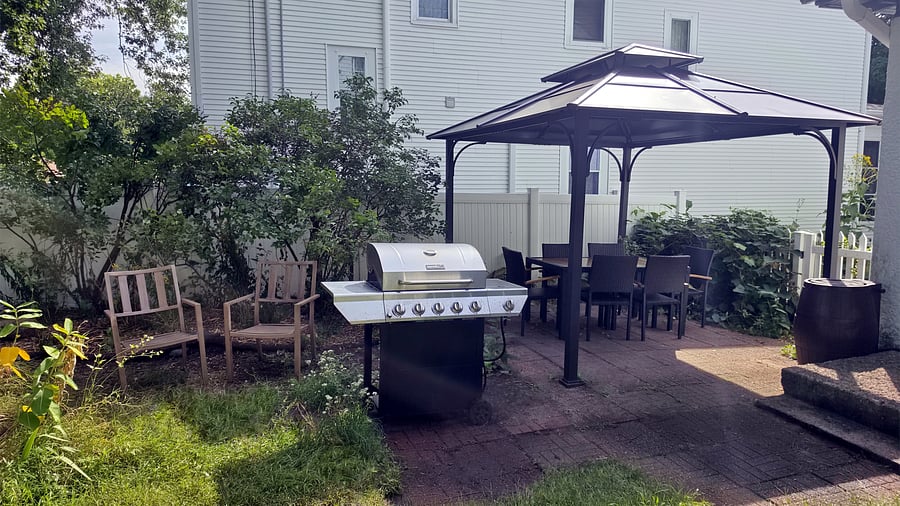 Enjoy outdoor meals and downtime in the private fenced backyard, with a covered dining gazebo, full-size gas grill and additional seating surrounded by mature greenery and gardens.