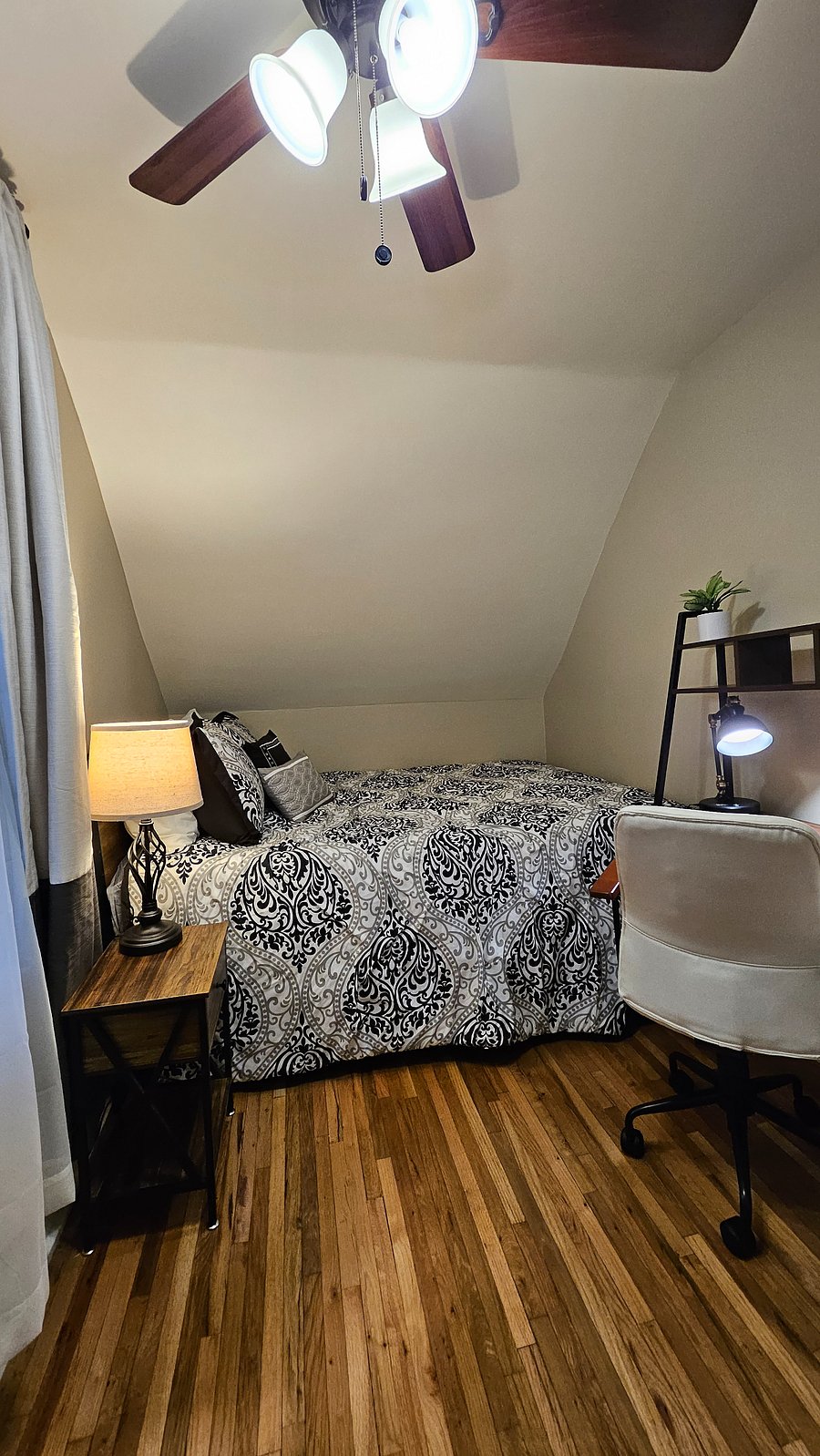 South queen bedroom with hardwood floors and natural light