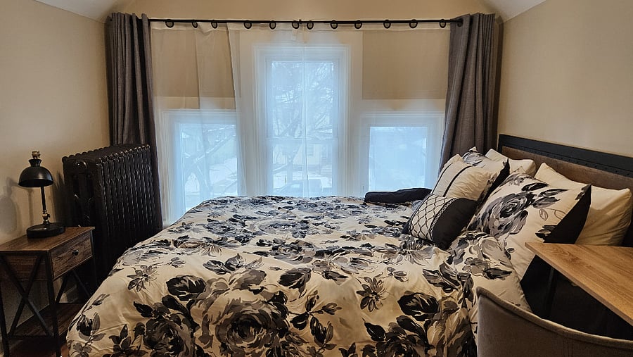 Large windows bring in natural light, while blackout curtains help create a restful night's sleep in the front bedroom.