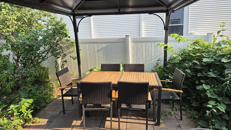 Enjoy meals outside beneath the gazebo, with a covered paver patio and table and chairs overlooking the fenced backyard.