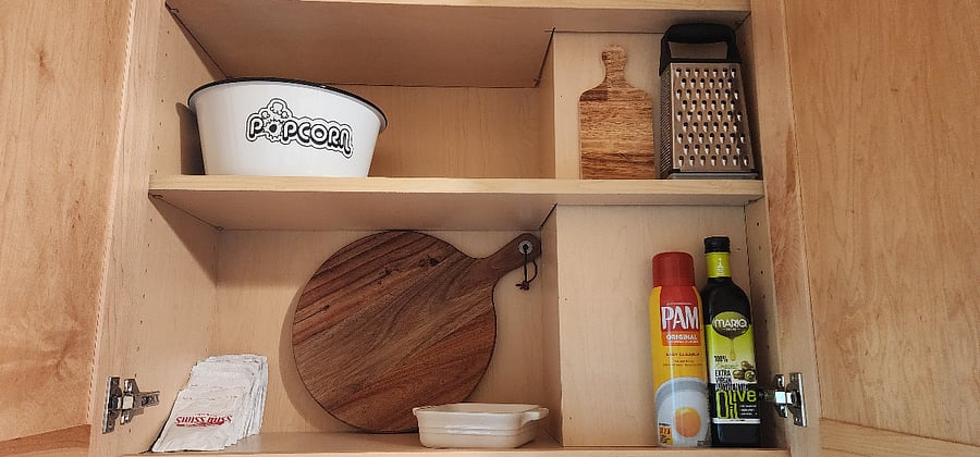 Cabinets are stocked with dishes, cookware, and serving pieces to support everyday cooking during longer stays.